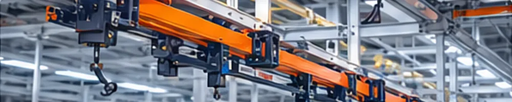 Power and free conveyor track with orange trolleys and load hooks